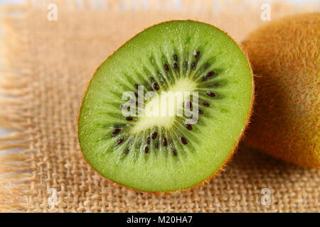 Schneiden Sie in kiwi Scheiben auf einem grauen Tabelle. Gesunde Ernährung Stockfoto