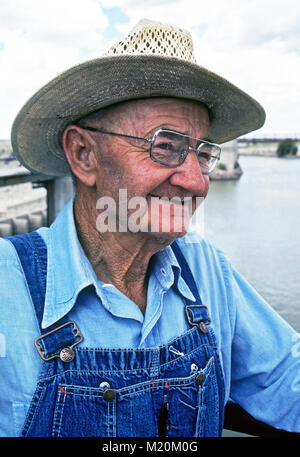 Ein älterer Bauer tragen Overalls und einen Strohhut, auf seiner Baumwolle Farm im Süden von New Mexiko. Stockfoto