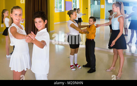 Gruppe von fleißigen freundlich lächelnden positive Kinder Tango tanzen im Tanzstudio Stockfoto