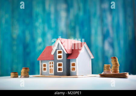 Rotes Haus auf hölzernen Hintergrund mit Banknoten Stockfoto