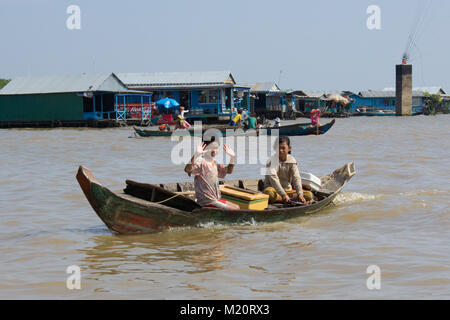 Siem Reap, Kambodscha - Januar 2014: Junge und Mädchen auf Boot verkaufen Getränke auf See Tonle Sap, Kambodscha - Stockfoto