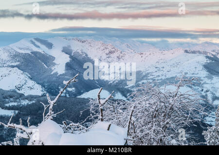 Sonnenaufgang in den Bergen von Ubina, zwischen Asturien und Leon, an einem Wintertag mit viel Schnee, in den frühen Morgenstunden zu fotografieren, die eindeutigen Farben Stockfoto