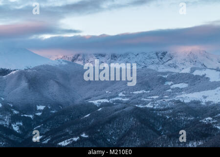 Sonnenaufgang in den Bergen von Ubina, zwischen Asturien und Leon, an einem Wintertag mit viel Schnee, in den frühen Morgenstunden zu fotografieren, die eindeutigen Farben Stockfoto