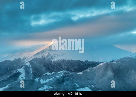 Sonnenaufgang in den Bergen von Ubina, zwischen Asturien und Leon, an einem Wintertag mit viel Schnee, in den frühen Morgenstunden zu fotografieren, die eindeutigen Farben Stockfoto