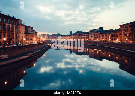 Blick auf den Fluss Arno in der Dämmerung mit Gebäuden, Licht und Wolken im Wasser, Pisa, Italien wider. Stockfoto