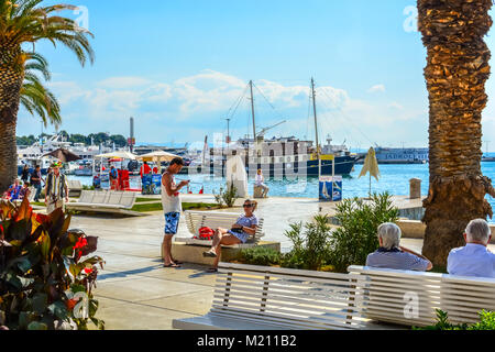 Touristen und Einheimische genießen Sie einen sonnigen Tag auf der bunten Dalmatinische Küste an der Uferpromenade Riva, Split Kroatien Stockfoto