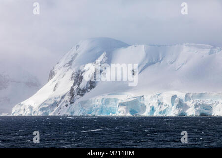 Dramatische Himmel über schnee- und eisbedeckten Antarktis Landschaft; Anvers Island Stockfoto