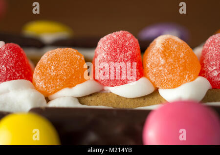 Nahaufnahme der farbenfrohe Bonbons in einer horizontalen Reihe angeordneten, der auf dem Dach eines Gingerbread House Stockfoto