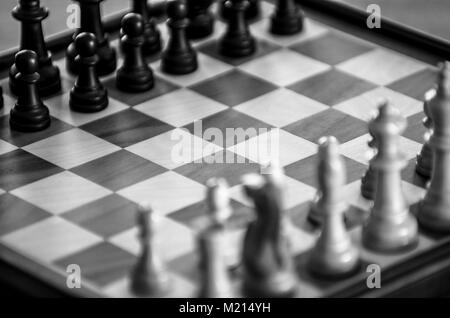 7/8-Ansicht von fantasiedekoren Schachbrett mit Stücken Ausgangspositionen unscharfe, schräg angeordnet und an schrägen Winkel betrachtet, monochromes Bild Stockfoto