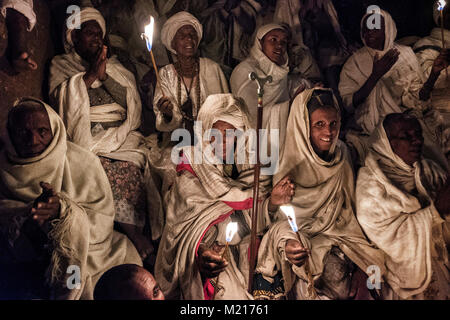 Lalibela, Amhara Region, Äthiopien. 6. Januar, 2018. Die Pilger beten mit Kerzen in der Nacht außerhalb der Biete Medhane Alem (Haus der Retter der Welt). In den ersten Tagen des Januar, Tausende Äthiopische Orthodoxe Christliche Pilger gehen an die Stadt Lalibela zum "neuen Jerusalem" besuchen. Dieser heiligen Stadt besteht aus 11 miteinander verbundenen Kirchen von Hand geschnitzt, die durch eine Reihe von Labyrinthen und Tunnels verbunden sind. Die ersten Tage des Januar die Feier von Genna (auch bekannt als ledet), der Weihnachten Version des äthiopischen Kalender markieren. Während dieser Feier Stockfoto