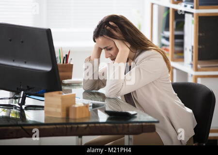 Junge Geschäftsfrau Kopfschmerzen Leiden am Arbeitsplatz Stockfoto