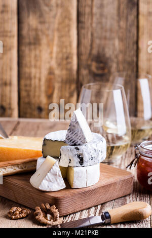 Vorstand mit verschiedenen Arten von Käse auf rustikalen Holztisch Stockfoto