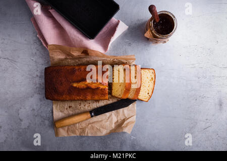 Hausgemachte Pound Cake auf Backpapier mit Konfitüre bereit zu Essen serviert, Ansicht von oben Stockfoto