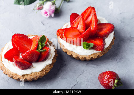 Erdbeer Torten mit Vanillesauce, köstliche Urlaub Obst Dessert auf hellgrauem Hintergrund Stockfoto