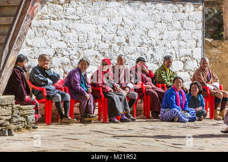 Prakhar Lhakhang, Bumthang, Bhutan. Bhutanesische Erwachsene Warten auf eine religiöse Performnance zu beginnen. Stockfoto