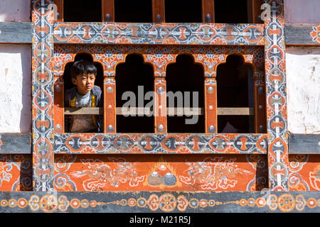 Prakhar Lhakhang, Bumthang, Bhutan. Junge durch ein Fenster in das Kloster. Stockfoto