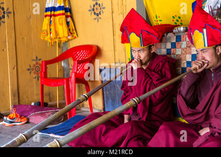 Prakhar Lhakhang, Bumthang, Bhutan. Buddhistische Mönche Spielen der Dungchen (Lange Trompete). Stockfoto