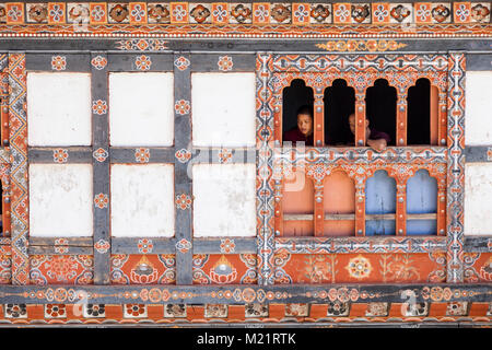 Prakhar Lhakhang, Bumthang, Bhutan. Junge Mönche beobachten Festival Tanz aus einem Fenster des Klosters. Stockfoto