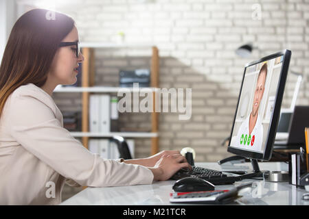 Junge Geschäftsfrau, Video Konferenz am Computer am Arbeitsplatz im Büro Stockfoto