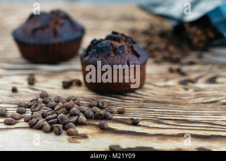 Frische und köstliche Kuchen und Kaffee duftenden Körner auf einem hölzernen Hintergrund. Mal Kaffee zu trinken. Stockfoto