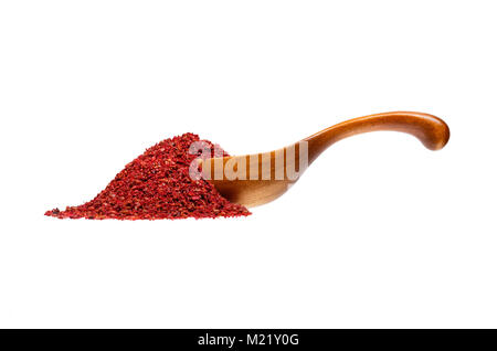 Sumac im Löffel aus Holz, auf weißem Hintergrund. Stockfoto