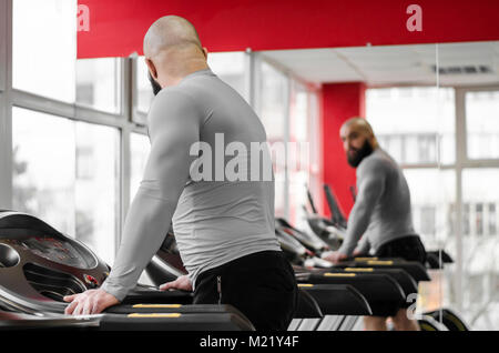 Mann Ausbildung auf dem Laufband, auf sein Spiegelbild im Spiegel auf der Suche nach Training Stockfoto