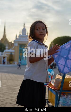 Kleines kambodschanisches Mädchen Verkauf von Speisen in der Straße vor dem Royal Palace, Phnom Penh, Kambodscha Stockfoto