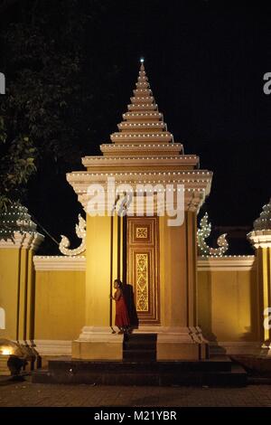 Kleines Mädchen versteckt im Türrahmen in Royal Palace Park, Phnom Penh, Kambodscha Stockfoto