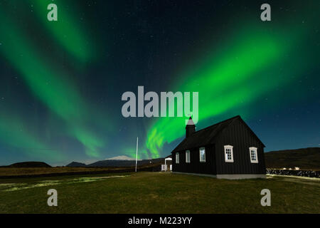 Nordlichter über die Schwarze Kirche Budir, Island. Aurora Borealis tolle Landschaftsfotos. Reiseziel mit wunderschönen grünen Lichter Landschaft Stockfoto