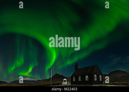 Nordlichter über die Schwarze Kirche Budir, Island. Aurora Borealis tolle Landschaftsfotos. Reiseziel mit wunderschönen grünen Lichter Landschaft Stockfoto