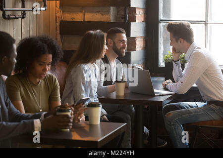 Diverse multirassischen junge Leute sprechen trinken Kaffee im gemütlichen Stockfoto