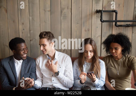 Tausendjährige multirassischen Freunden über Mobiltelefone und Reden ein Stockfoto