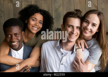 Zwei afrikanische und kaukasische Paare umfassenden Blick auf Kamera, p Stockfoto