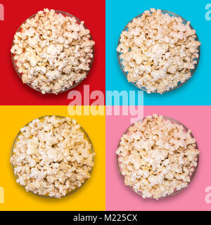 Popcorn in eine transparente Platte auf einem roten, blauen, gelben und rosa Hintergrund Stockfoto