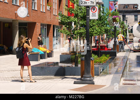 Junge Frau, ein Foto mit Ihrem Smart Phone auf Emery Street, Montreal, Quebec, Kanada. Stockfoto