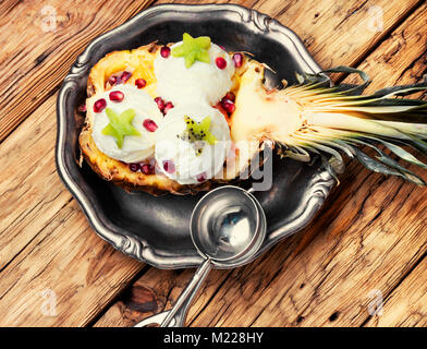 Eis in der Ananas Schüssel, dekoriert mit Kiwi und Granatapfel. Eis Dessert Stockfoto