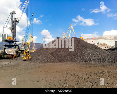 Noworossijsk, Russland - Oktober 10, 2017: Haufen Kohle anthrazit im Hafen. Hafen Kräne für Kohle zu laden. Stockfoto