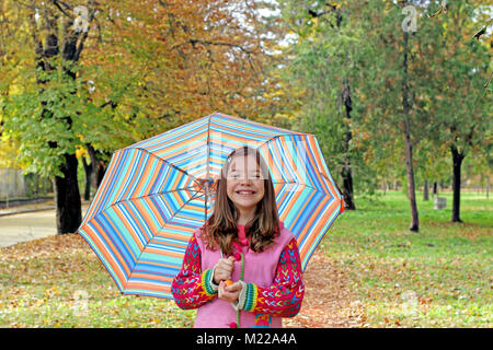 Glückliche kleine Mädchen mit Regenschirm Herbst Stockfoto
