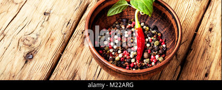 Schwarz, rot und weißem Pfeffer in Ton Schüssel. Gemischte Pfefferkörner Stockfoto