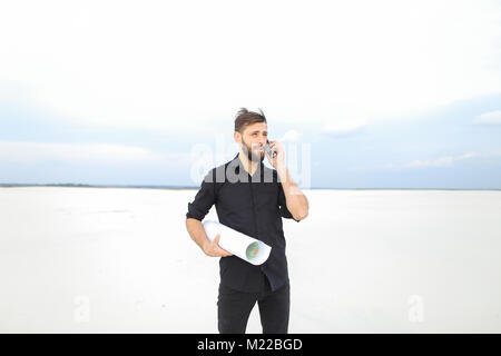 Kleidung Designer über Smartphone mit Bruder zu kommunizieren Stockfoto