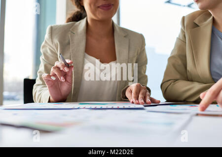 Nahaufnahme der unkenntlich Team von Financial Manager diskutieren statistische Daten während des Arbeitstreffens in modernen Sitzungssaal Stockfoto