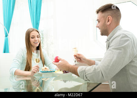 Portrait des jungen Mannes schlägt Freundin am Valentines Tag zum Abendessen im Restaurant sitzen und trinken Champagner Stockfoto