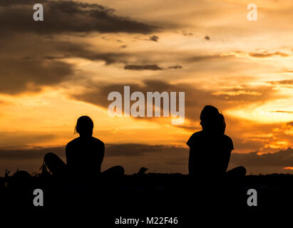 Yoga am Strand während einer spektakulären Sonnenuntergang Stockfoto