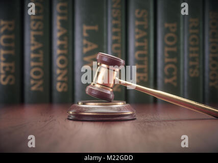 Holz- Hammer mit goldfarbenen Details und Bücher in den Hintergrund. Stockfoto