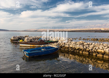 Holz- Ruderboot - alte Fischerboote in alten steinernen meer Hafen auf der Insel Pag, Kroatien Stockfoto