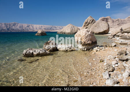 Schönen Sandstrand mit grossen Felsen und Türkis blaues Wasser auf der Insel Pag, Kroatien Stockfoto