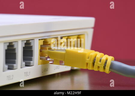 Netzwerkkabel angeschlossen Router auf Metall Tisch mit Reflexion zu Internet Stockfoto