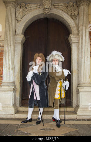 Karneval in Venedig - Gentleman Venezianische Masken im eleganten Kostüm auf dem Markusplatz in Venedig. Stockfoto