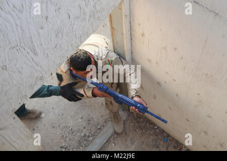 Ein irakischer Soldat demonstriert, wie ein Zimmer in Bagdad Operations Command Training im Camp Besmaya 30. Dez. 2017 eingeben. Die Schulung ist Teil des gesamten Combined Joint Task Force - inhärenten Building Partner Kapazität mission lösen, die über die Ausbildung und die Verbesserung der Fähigkeit der zusammengeschlossen, um Kräfte, die ISIS konzentriert. CJTF-OIR ist die globale Koalition zu besiegen ISIS im Irak und in Syrien. (U.S. Armee Stockfoto