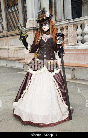 Weibliche Venezianische Maske mit Gewehr auf den Markusplatz in Venedig - Karneval in Venedig Stockfoto